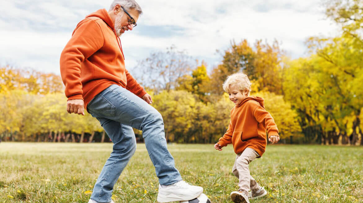 father and son playing soccer - lifestyle image